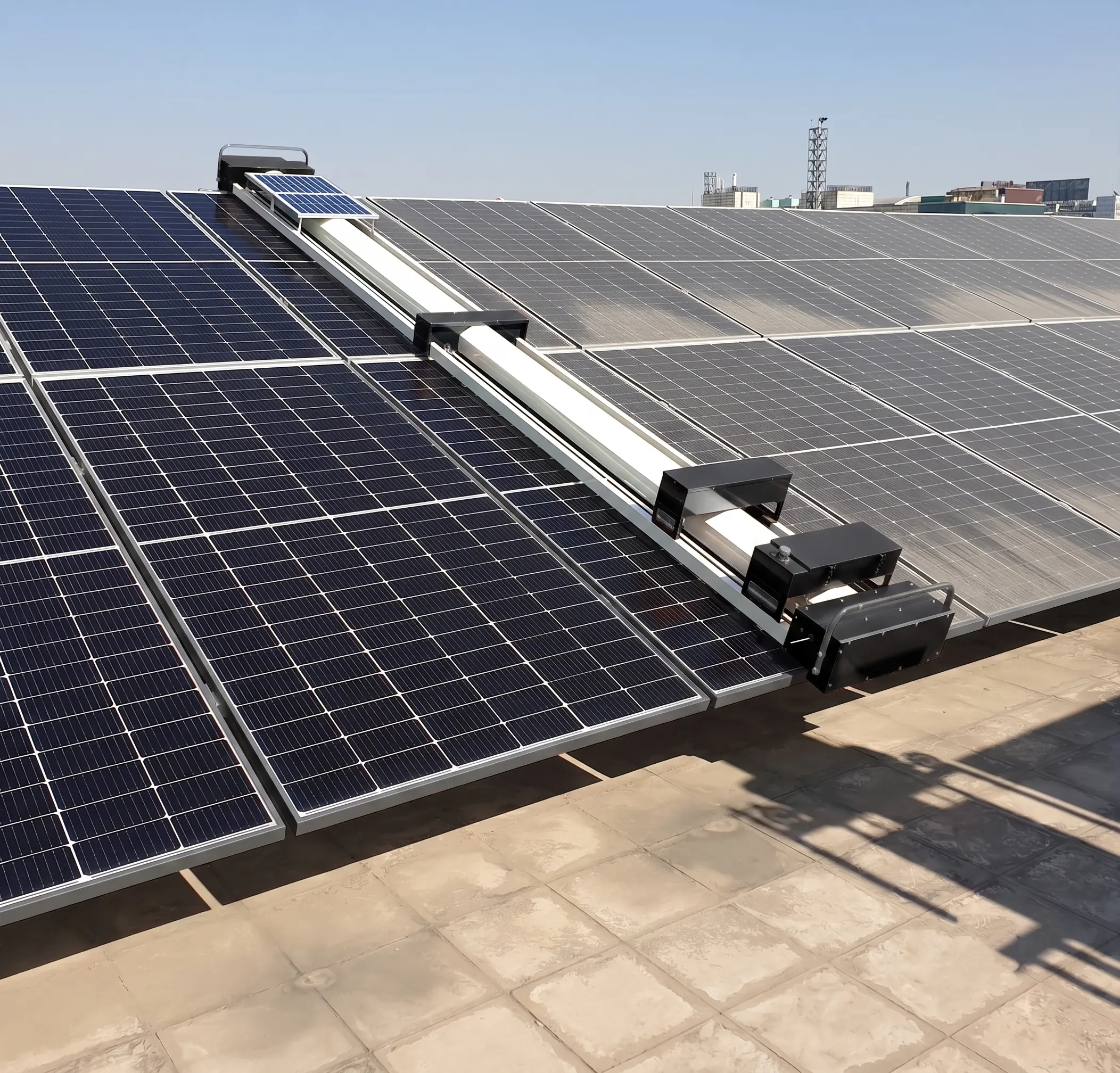 Droid cleaning robot moving along a long row of ground mount utility solar panels with full array visible in the background