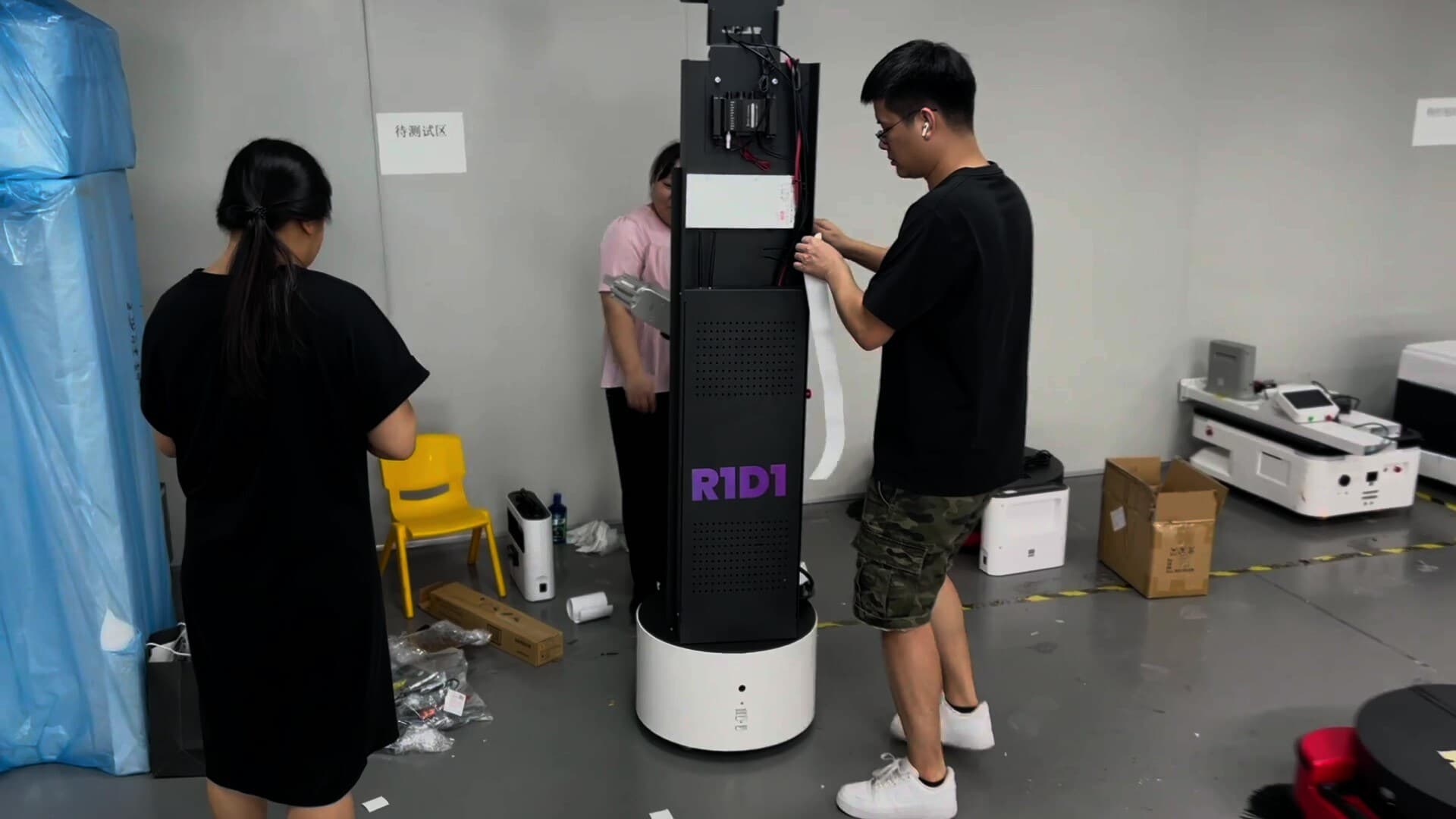 Campus hallway or STEM lab with an Droid robot mid-task alongside students actively engaged