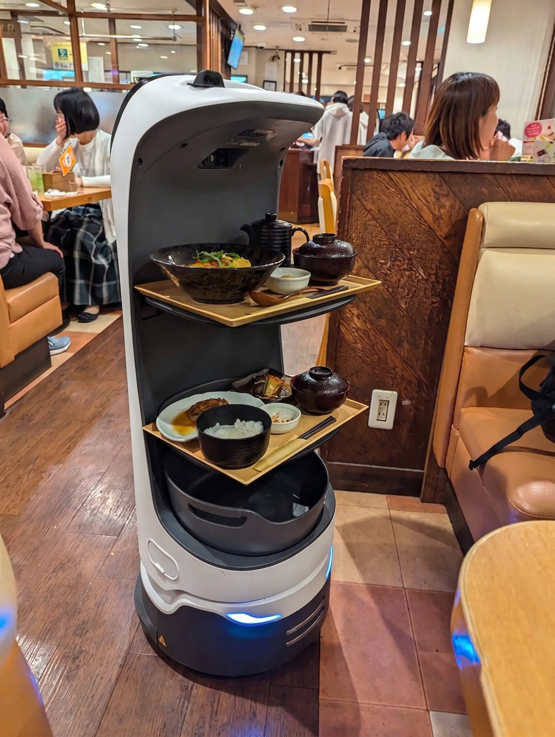 Droid restaurant robot operating in a busy dining room