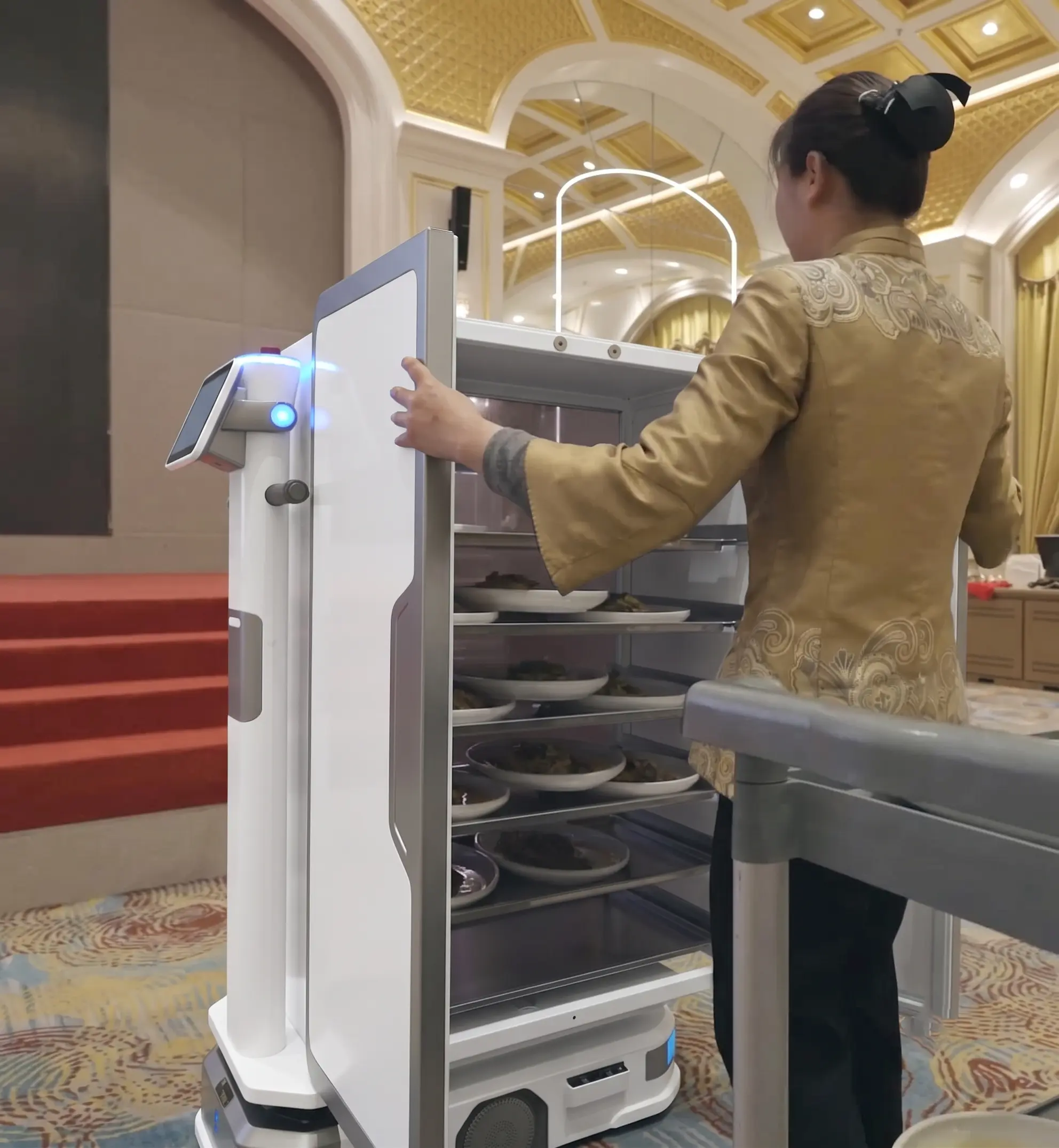 Droid delivery robot carrying a to-go order through a restaurant parking lot