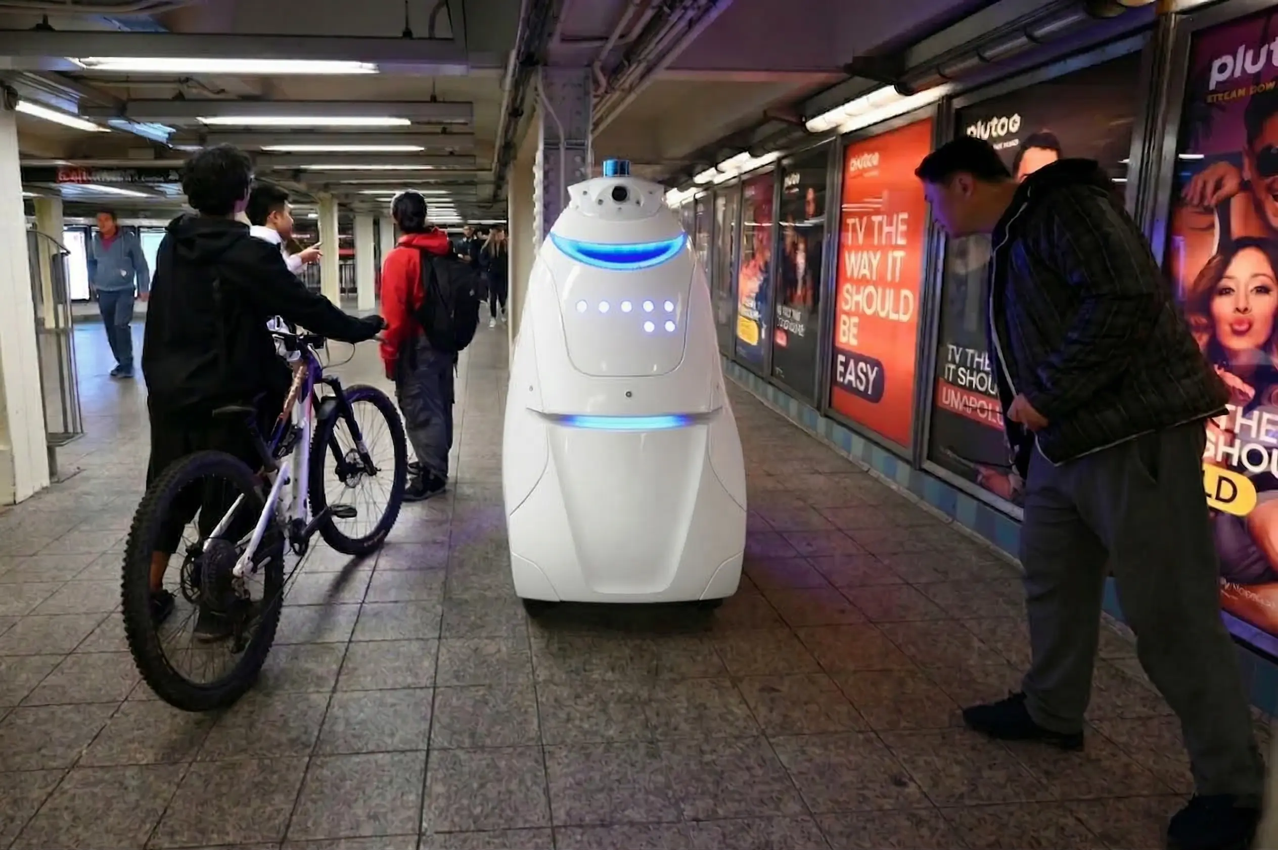 Droid patrol robot moving through a hotel parking structure at night with a visible sensor array
