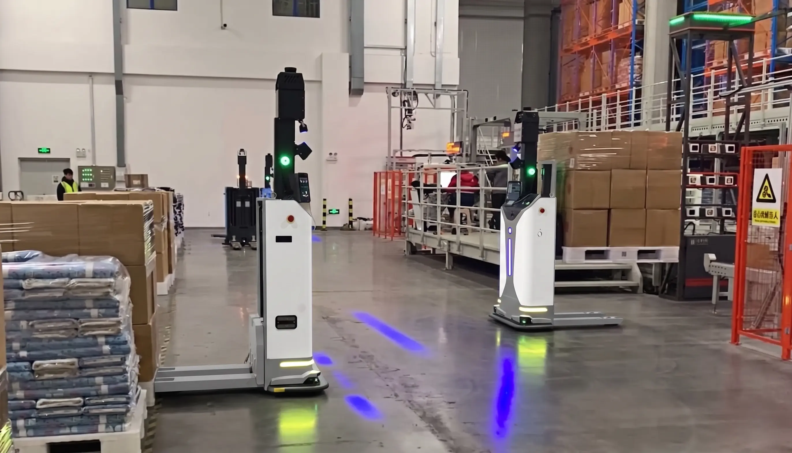 Droid robot routing totes toward labeled sortation chutes in a warehouse